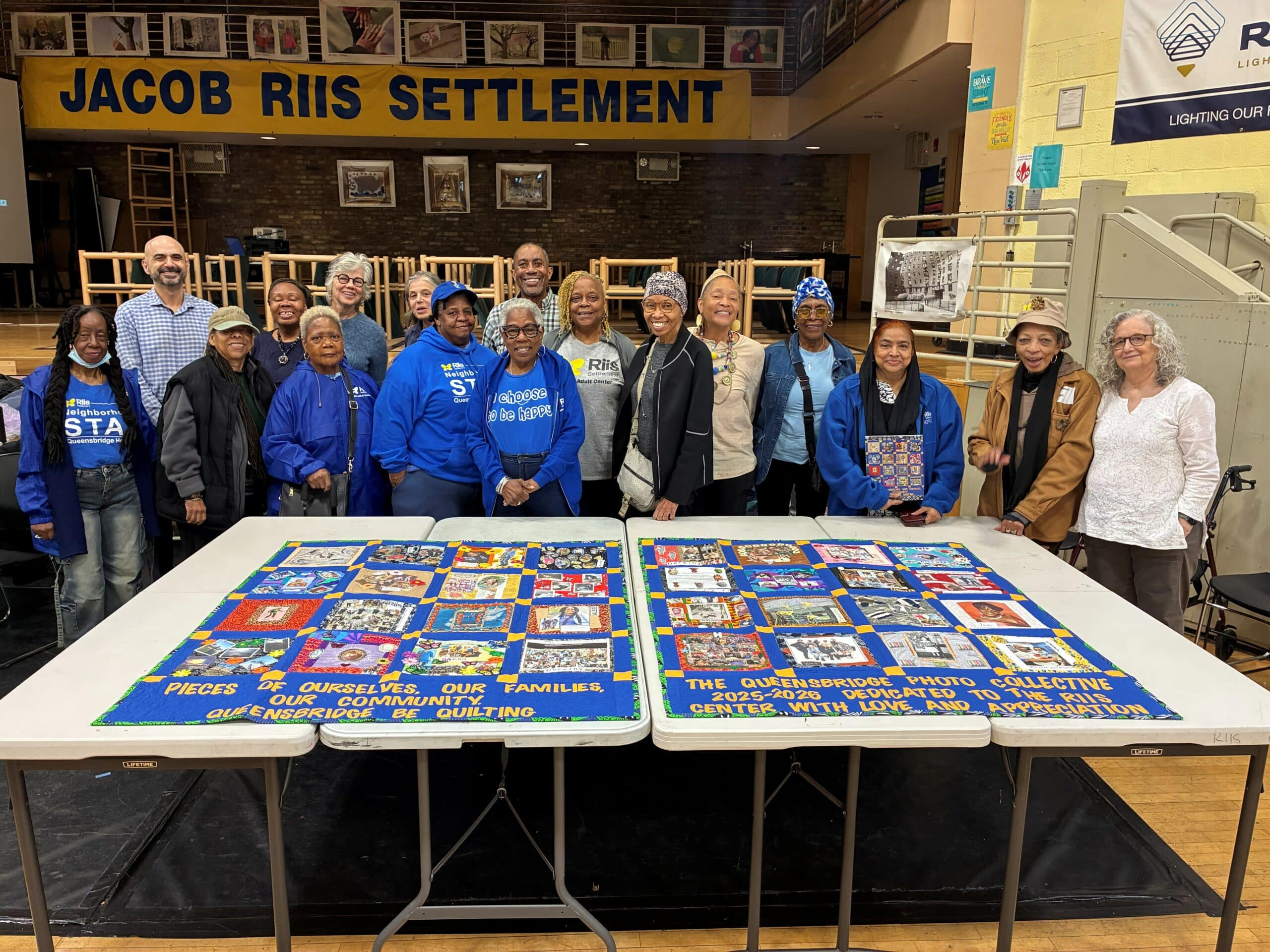 Queensbridge Photo Collective group posed behind completed quilt